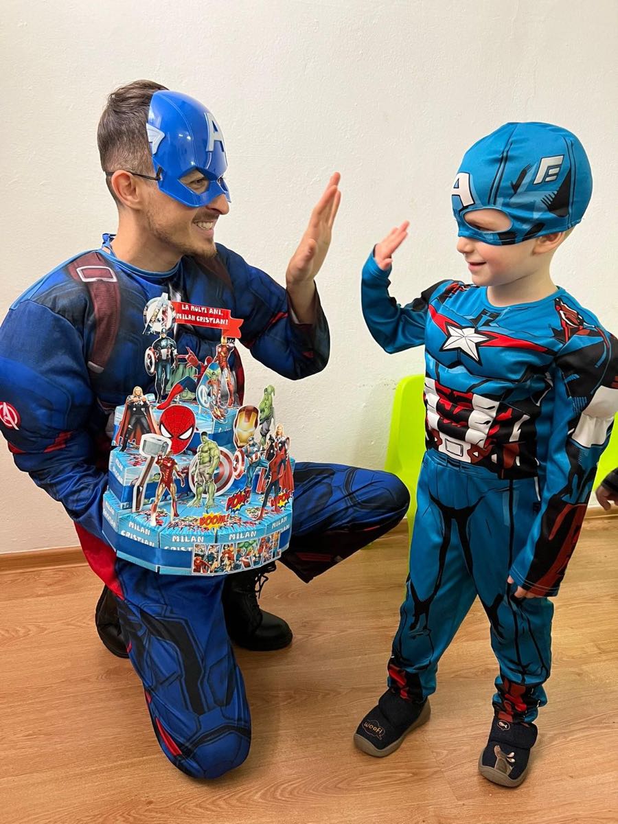 Cărucior roz de vată de zahăr lângă un perete de baloane, la o petrecere