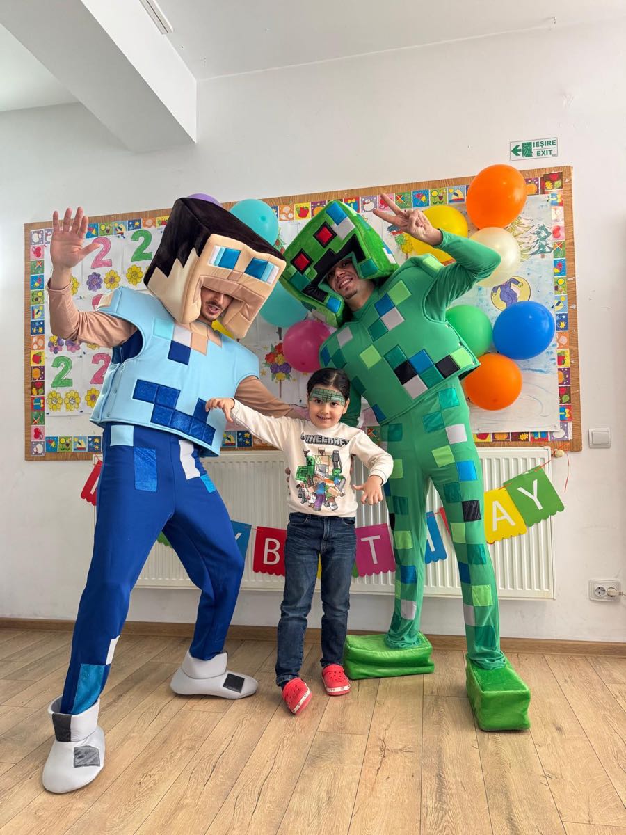 Doi animatori în costume de personaje alături de sărbătorit, la o aniversare la grădiniță
